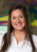 A woman with long brown hair wearing a white shirt