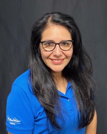 Gabriela Luna, wearing a NeighborWorks shirt, smiles at the camera.