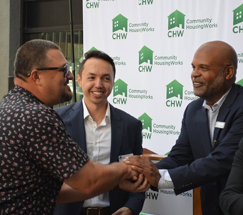 Sean Spear speaks with two men of color at a Community HousingWorks event in California