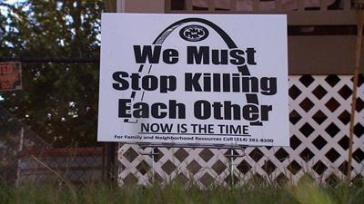 Signs that say "We must stop killing each other"