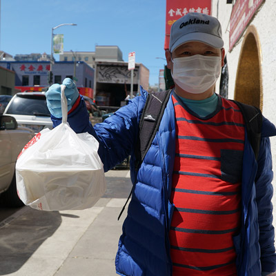 A Chinatown CDC employee delivers food to residents