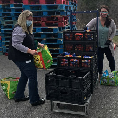 Volunteers assist residents in need by packing boxes of goods