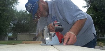 A man does some work cutting a board. Spaces must be sealed.