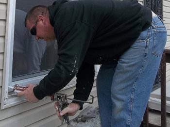 A worker seals a window.