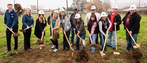 The community dips shovels into the ground as the ceremony ends in smiles.