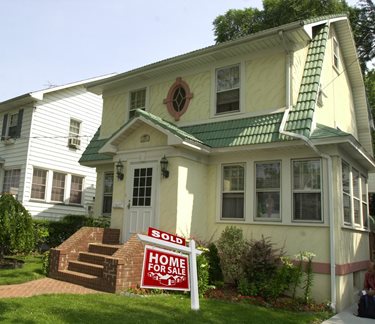 A home with a sold sign in front of it.