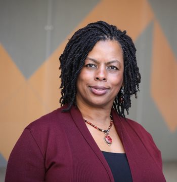 Yvette Holmes in a burgundy top, looks directly at the camera.