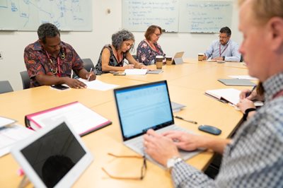 Doing the hard work, a cohort gathers around a table to concentrate and work.