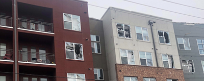 Apartment buildings show the damage of the tornado -- broken window after broken window.