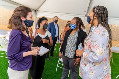 Leaders gather at the groundbreaking, outside and under a tent.