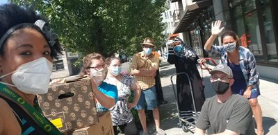 Food distribution at REACH. Volunteers pose with boxes.