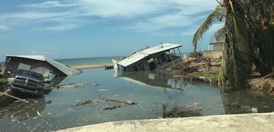 Photo shows town dealing with damage from a hurricane, with a high water level. Houses can be seen surrounded by standing water.