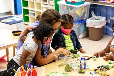 Students study butterflies with their teacher.