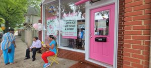 Women sit outside the ice cream shop.