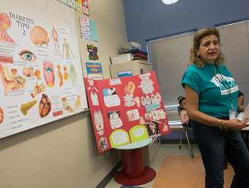 A woman wearing a blue shirt teaches kids about health and exercise