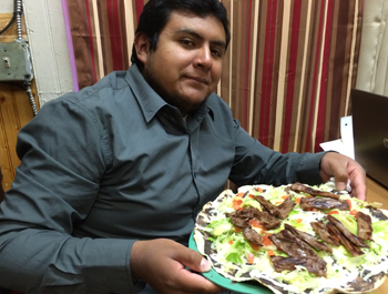 A Hispanic man holds a plate of food