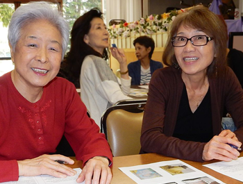 Two Asian seniors sit at a table learning about financial security