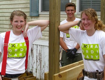 Two white women lean against a wooden beam