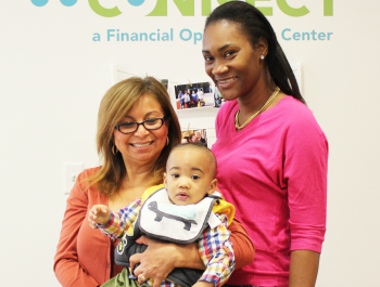 Two women and a baby boy smiling to the camera.