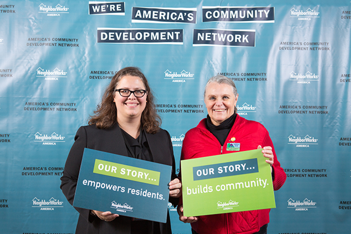 Sheila Rice stands in front of a banner that says We're America's Community Development Network