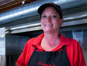 A woman wearing a red shirt with text that reads "Champ's diner"