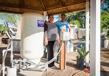 A California couple stands next to one of the new water tanks